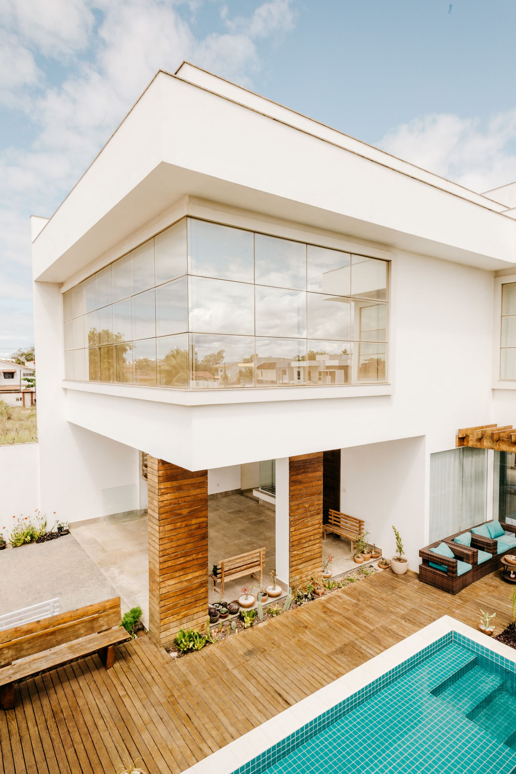 Modern glass-fronted home with a timber terrace and swimming pool